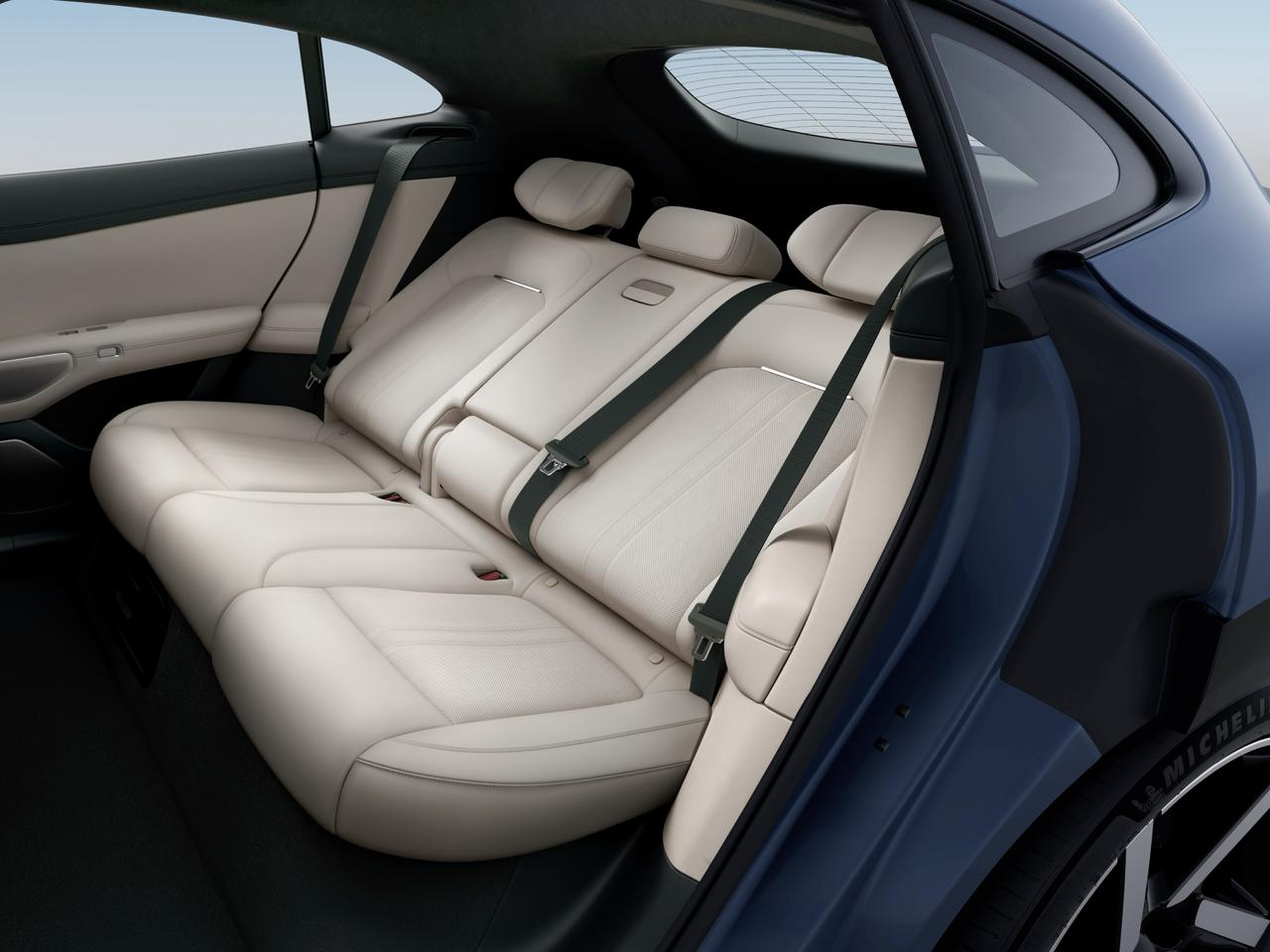 L'interno del sedile posteriore dell'auto presenta sedili in pelle beige e cinture di sicurezza. Lo sfondo include i finestrini dell'auto e l'ambiente interno, con un design complessivo moderno e minimalista.