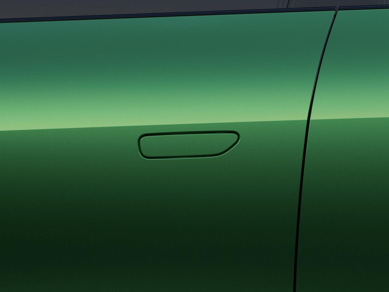 Parte della carrozzeria dell'auto verde, il contorno della maniglia della porta è prominente, la superficie è liscia, presentando un effetto verde sfumato.