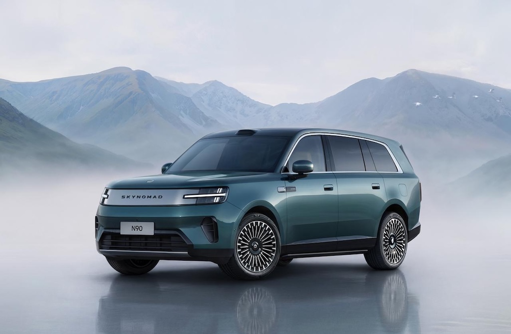 A green SUV is parked against a backdrop of misty mountains, featuring a modern body design and large wheels. The front emblem displays the brand name "SKY NOMAD," and the license plate number is "N90."