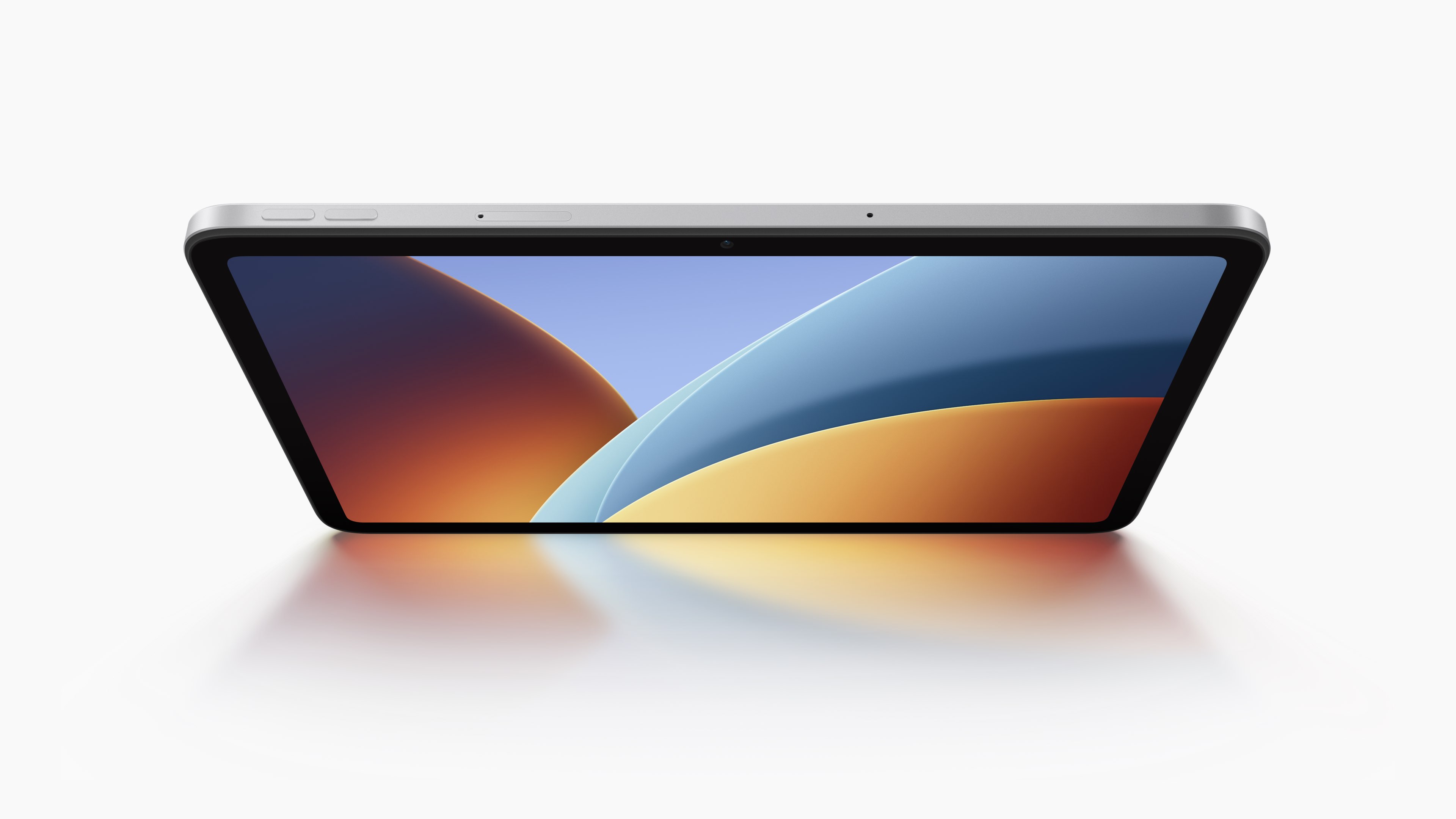 A tablet is facing up, displaying a colorful screen with a white background.