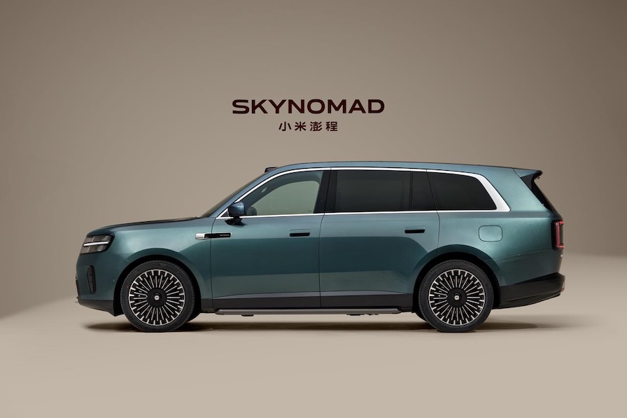 A cyan SUV named "SKYNOMAD," showcased from the side against a light-colored background. The car's design is modern, featuring unique wheels.