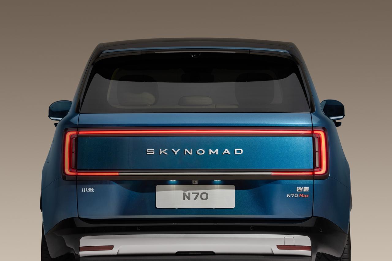 A rear view of a blue SUV, with the markings "SKYNOMAD" and "N70 Max" on the body, unique tail light design, and a white rear bumper at the bottom. The background is a gradient color, highlighting the vehicle's appearance.