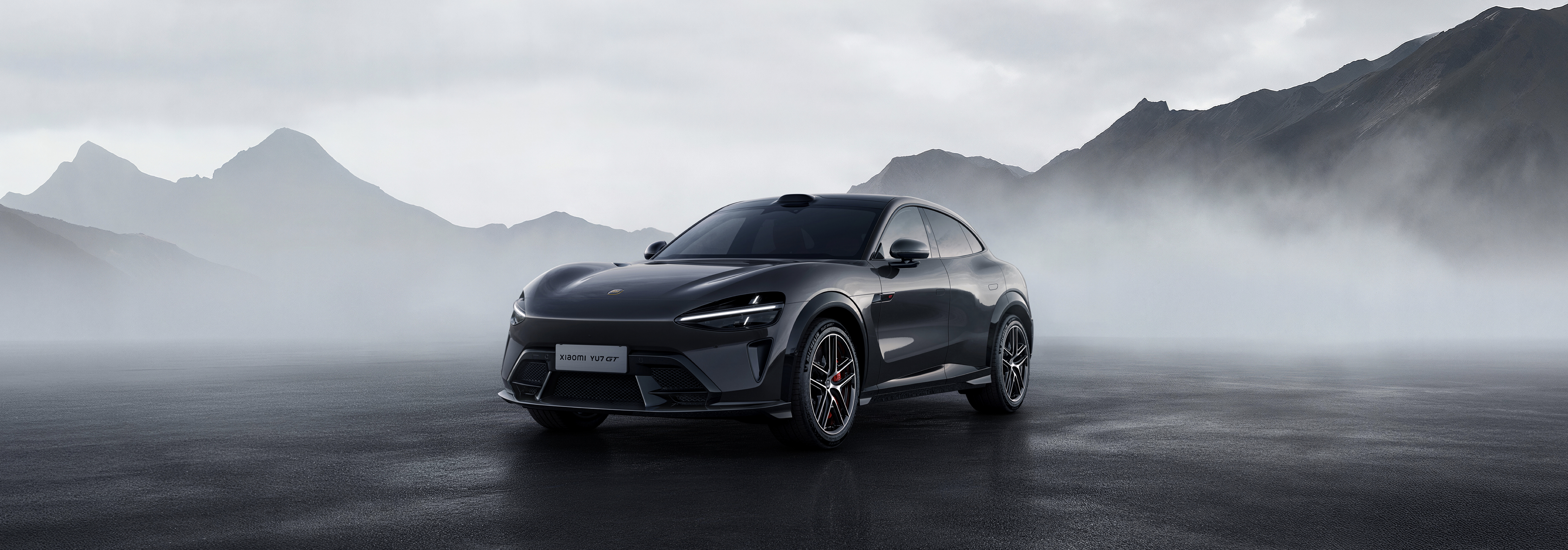 A black sports car is parked in front of a misty mountainous background, surrounded by hazy mountains, creating an atmosphere that feels mysterious and modern.