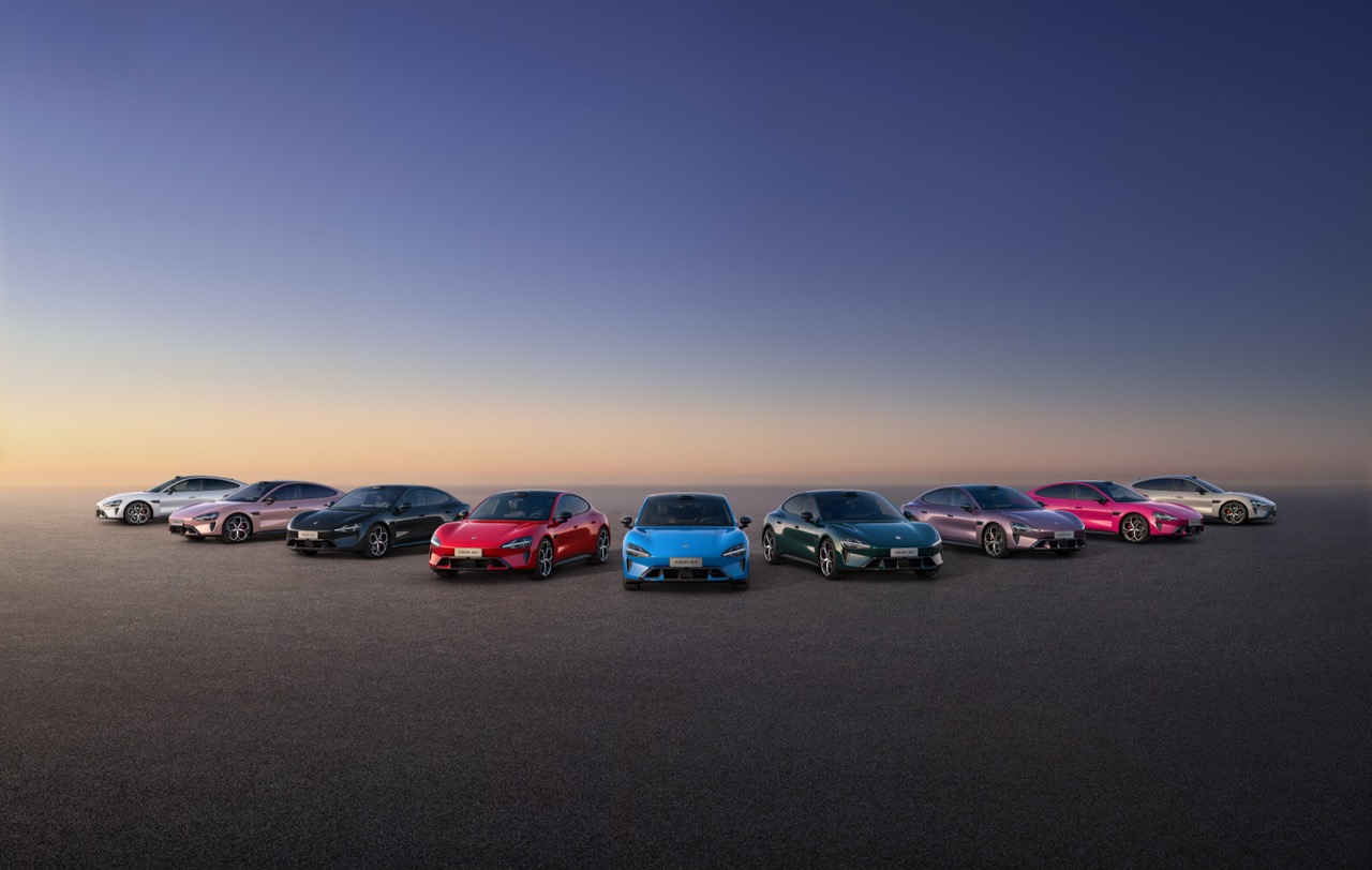 A variety of sports cars in different colors are lined up together, with a gradient sky in the background and an empty road surface beneath.