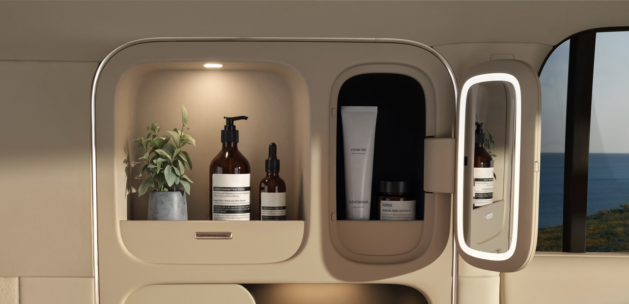 A delicate storage cabinet with several bottles of skincare products and a potted plant inside. There is lighting above the cabinet, and a small mirror next to it, with a sea view in the background.