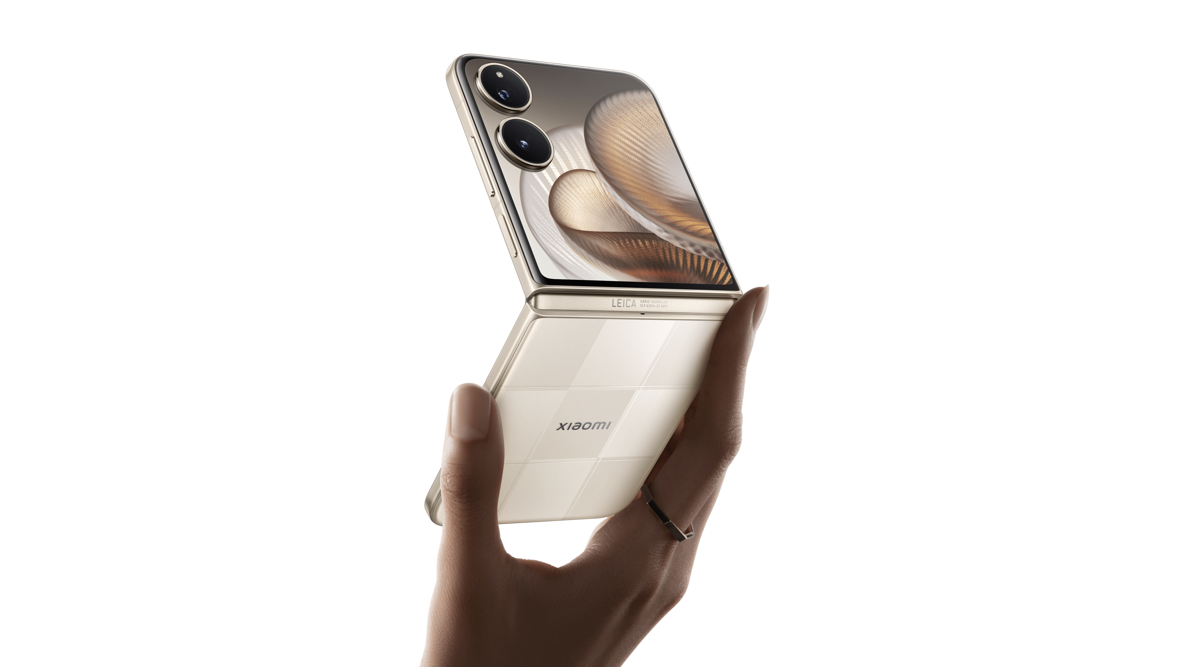 A hand is holding a flip phone, the front screen displays a unique pattern, and the back has the Xiaomi logo and the word Leica.