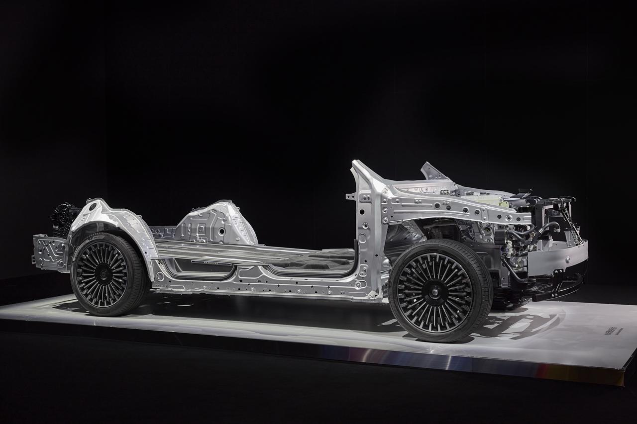 A showcase of an electric vehicle chassis, made of silver metal material, equipped with a tire and some mechanical components, with a black background and a display stand at the bottom.