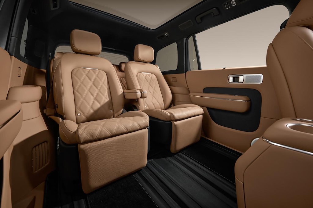 The seats inside the car are made of brown leather, featuring an exquisite design that conveys a sense of luxury. The seats are equipped with backrests and armrests, and the overall layout is spacious, set against a minimalist interior environment.