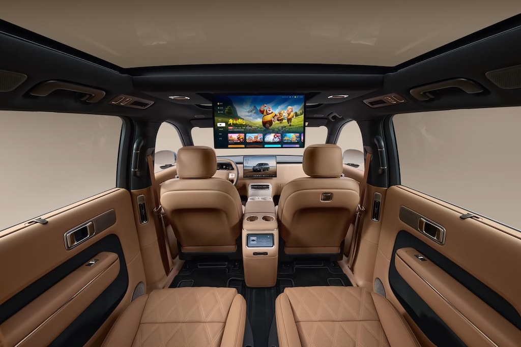 Showcasing the car interior, equipped with brown leather seats and a modern central console, featuring a large screen in the center that displays animated content. The interior environment is clean and full of a sense of technology.
