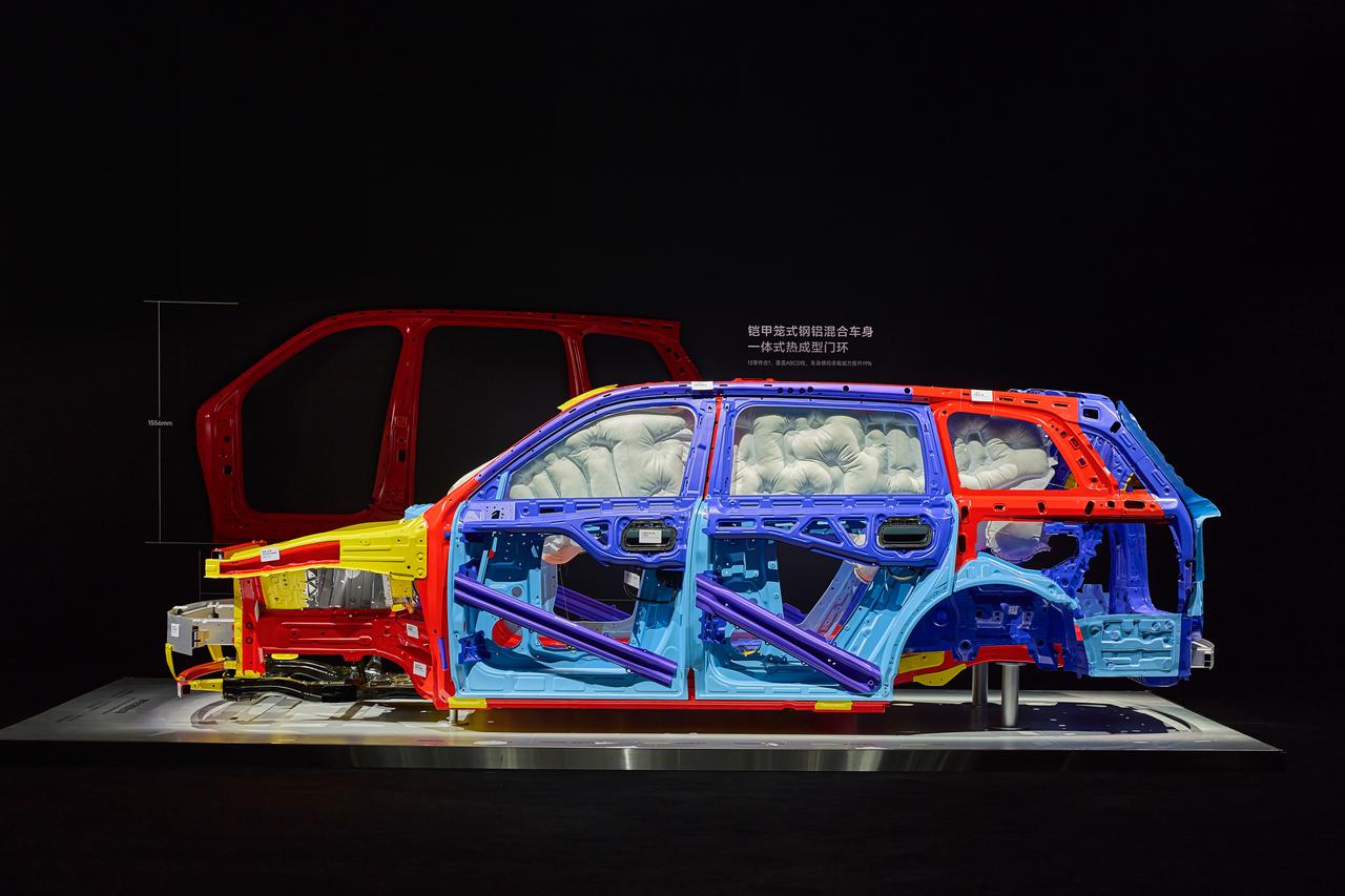 A disassembled car body is displayed, with some structures presented in blue, red, and yellow against a black background. The airbags and other components inside the car body are clearly visible, showcasing the details of automotive design and safety features.