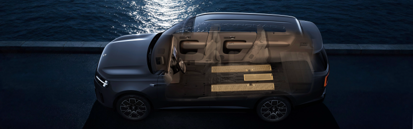 It shows a cross-sectional view of a car, clearly displaying the internal layout, especially the design of the seats and floor. The background features reflections of light on the water, creating a sense of modernity and technology.