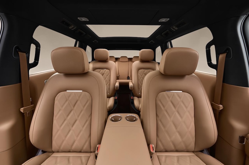 Luxury car interior, with light brown leather seats, exquisitely designed, featuring an armrest and cup holders in the center. The interior space is spacious, with a sunroof on top, creating a modern and comfortable overall atmosphere.